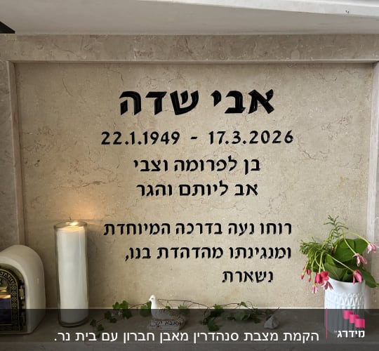 מצבה עם נר זיכרון ופרחים